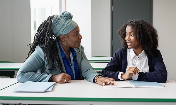 two women at a desk talking